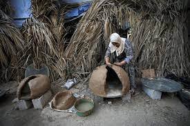 Inshirah Salem al-Aqra, preparing an Oven